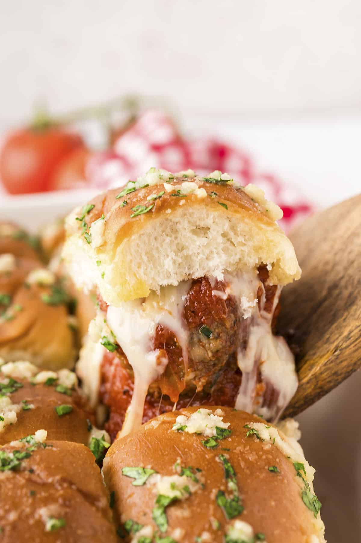 Meatball sliders being removed from pan.