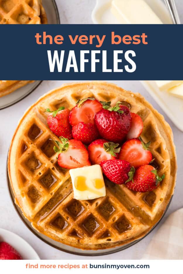 Belgian waffles topped with strawberries and syrup.