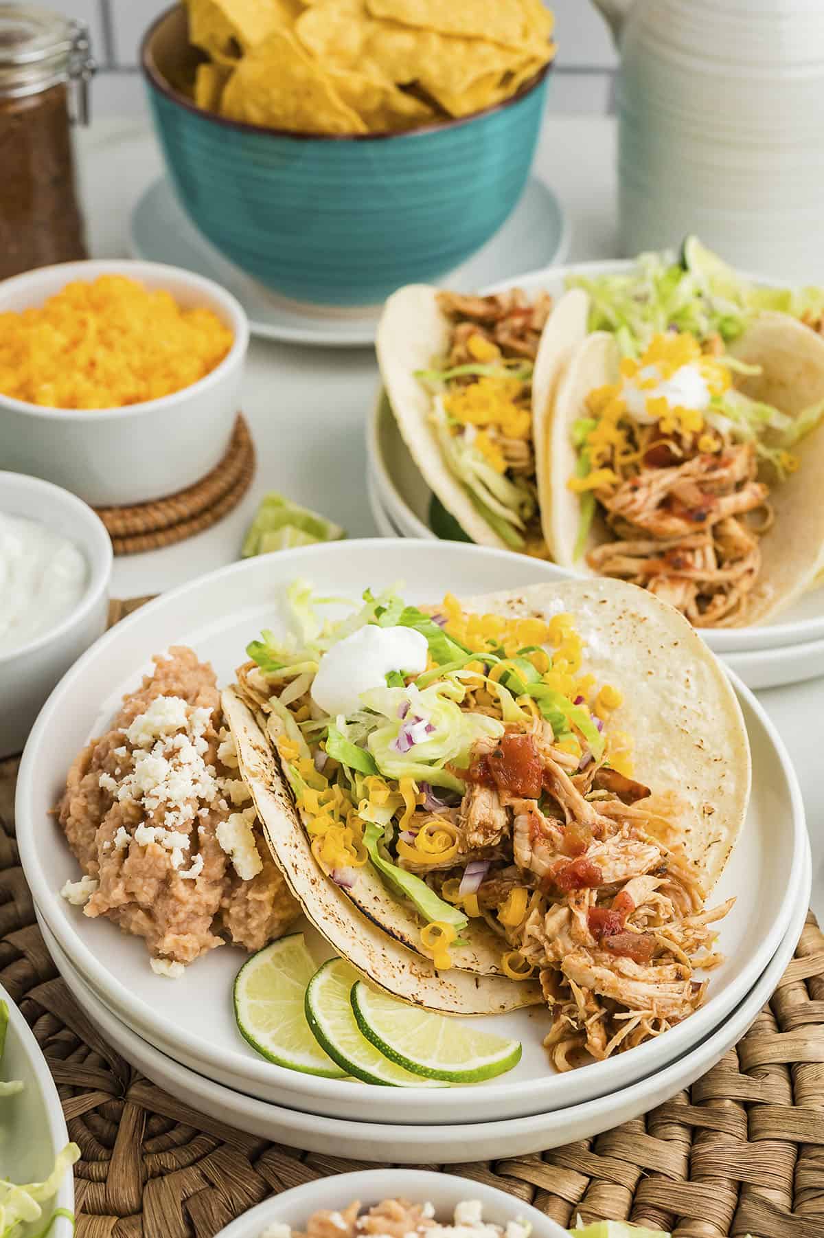 Shredded chicken taco on small plate.