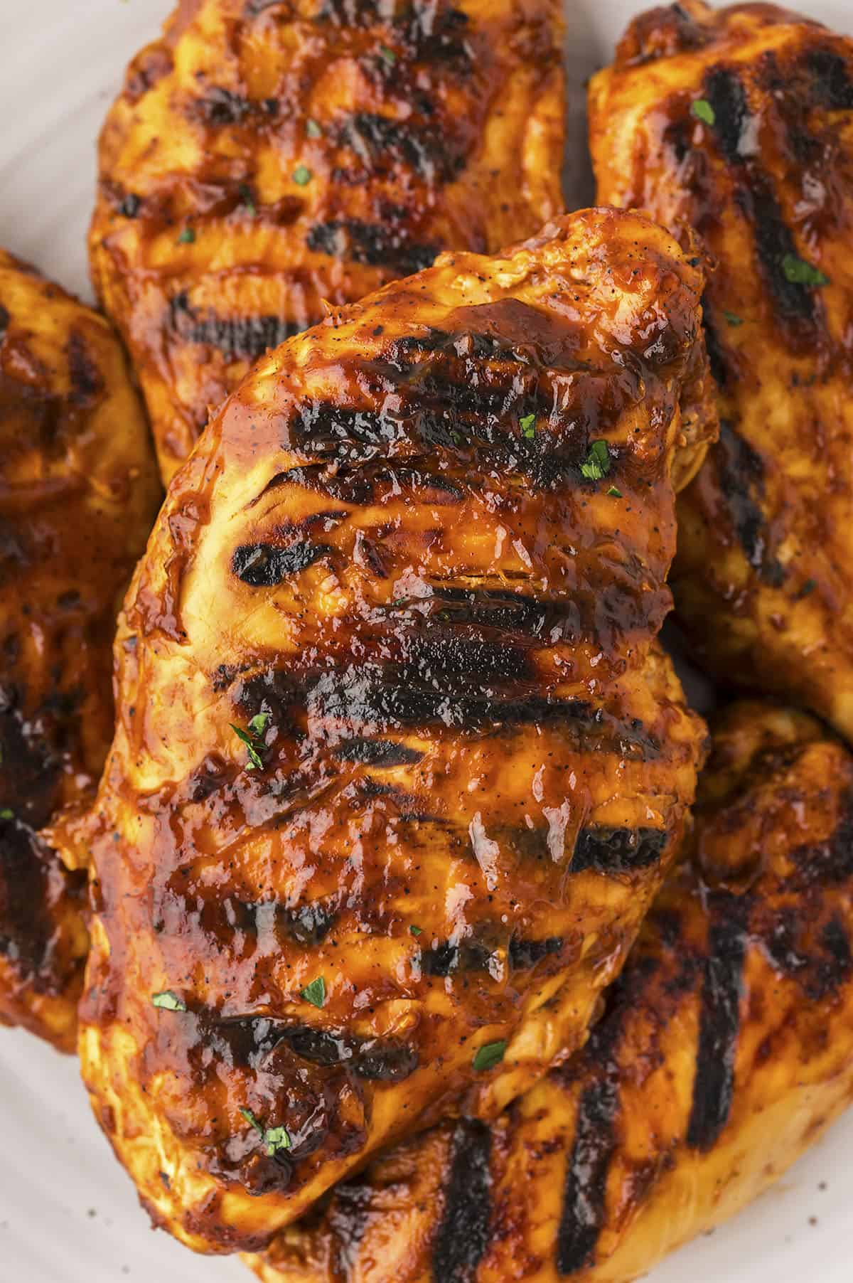 Grilled barbecue chicken recipe piled together on plate.