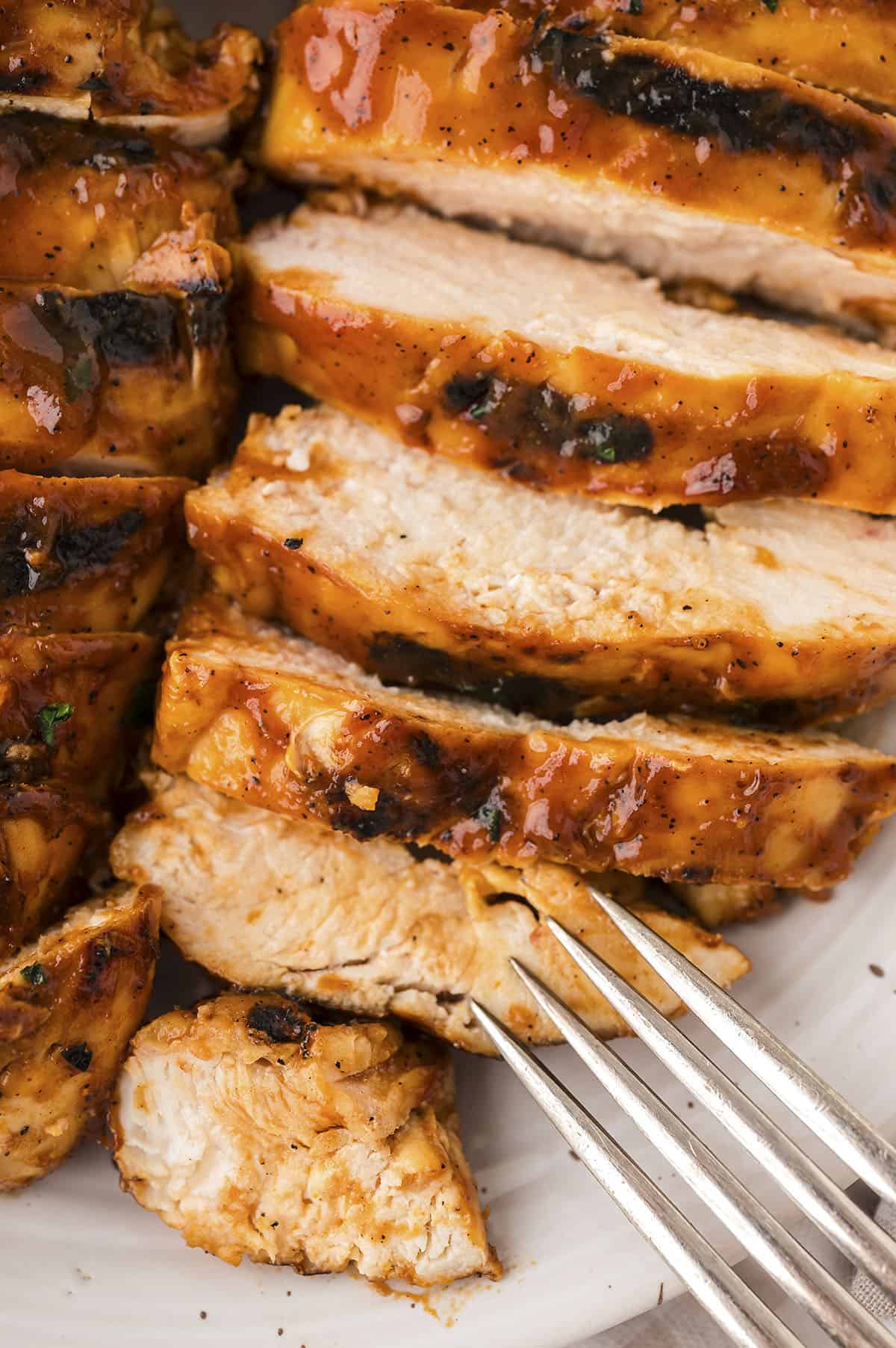 Sliced bbq grilled chicken on plate.