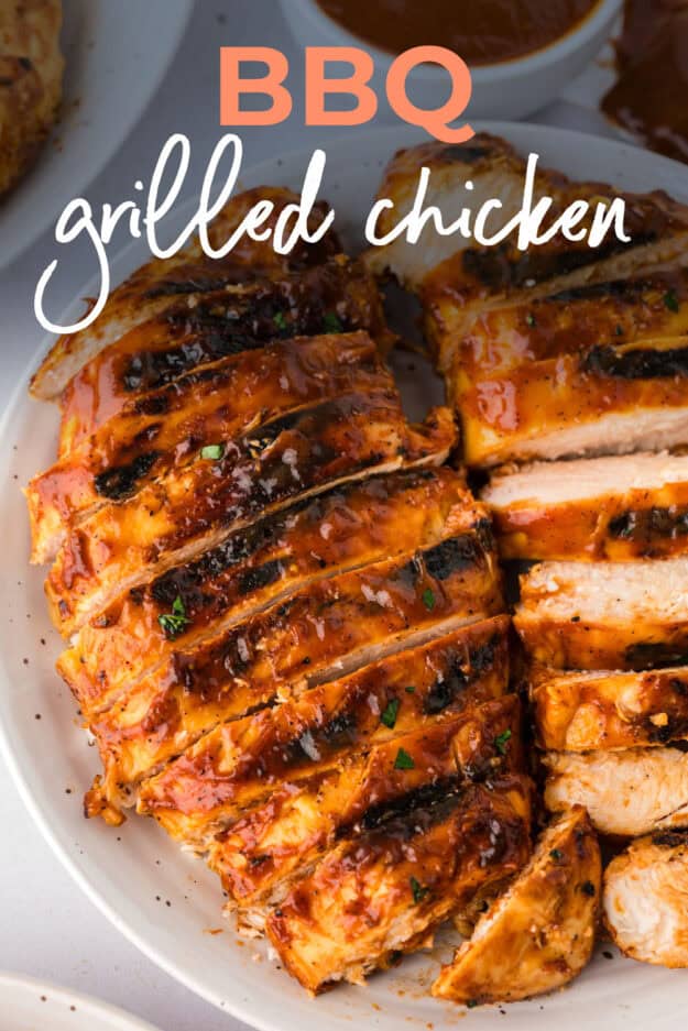 Sliced chicken breasts grilled with bbq sauce on plate.