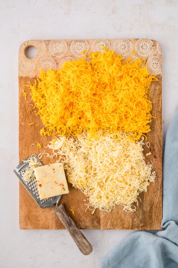 Grated cheese on wooden board.