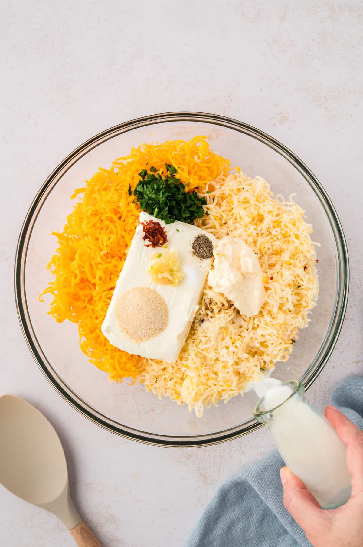 Ingredients for cheese spread in glass bowl.