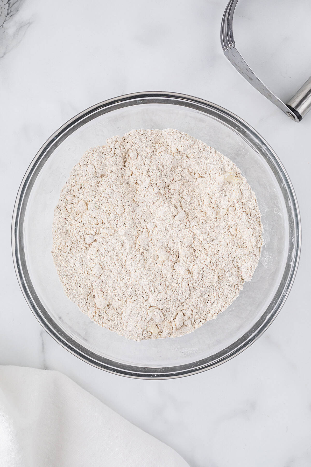 Butter and flour cut together in glass bowl.