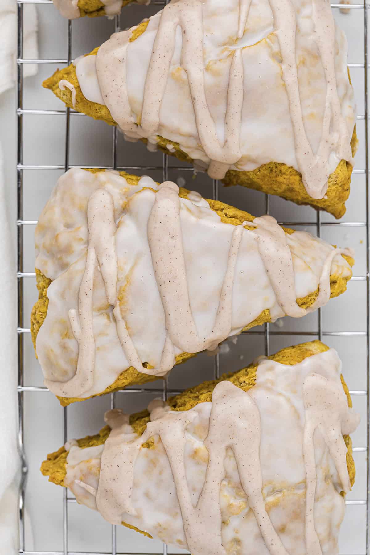 Glazed pumpkin scones on cooling rack.