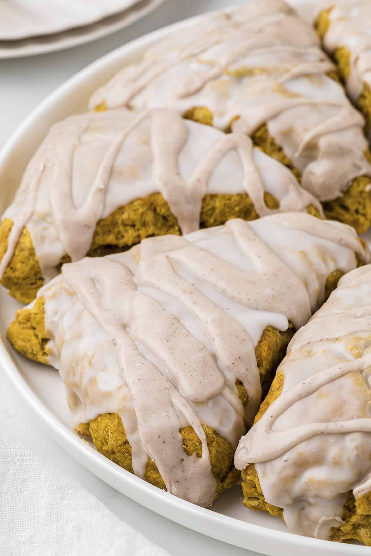 Double glazed pumpkin scones on plate.