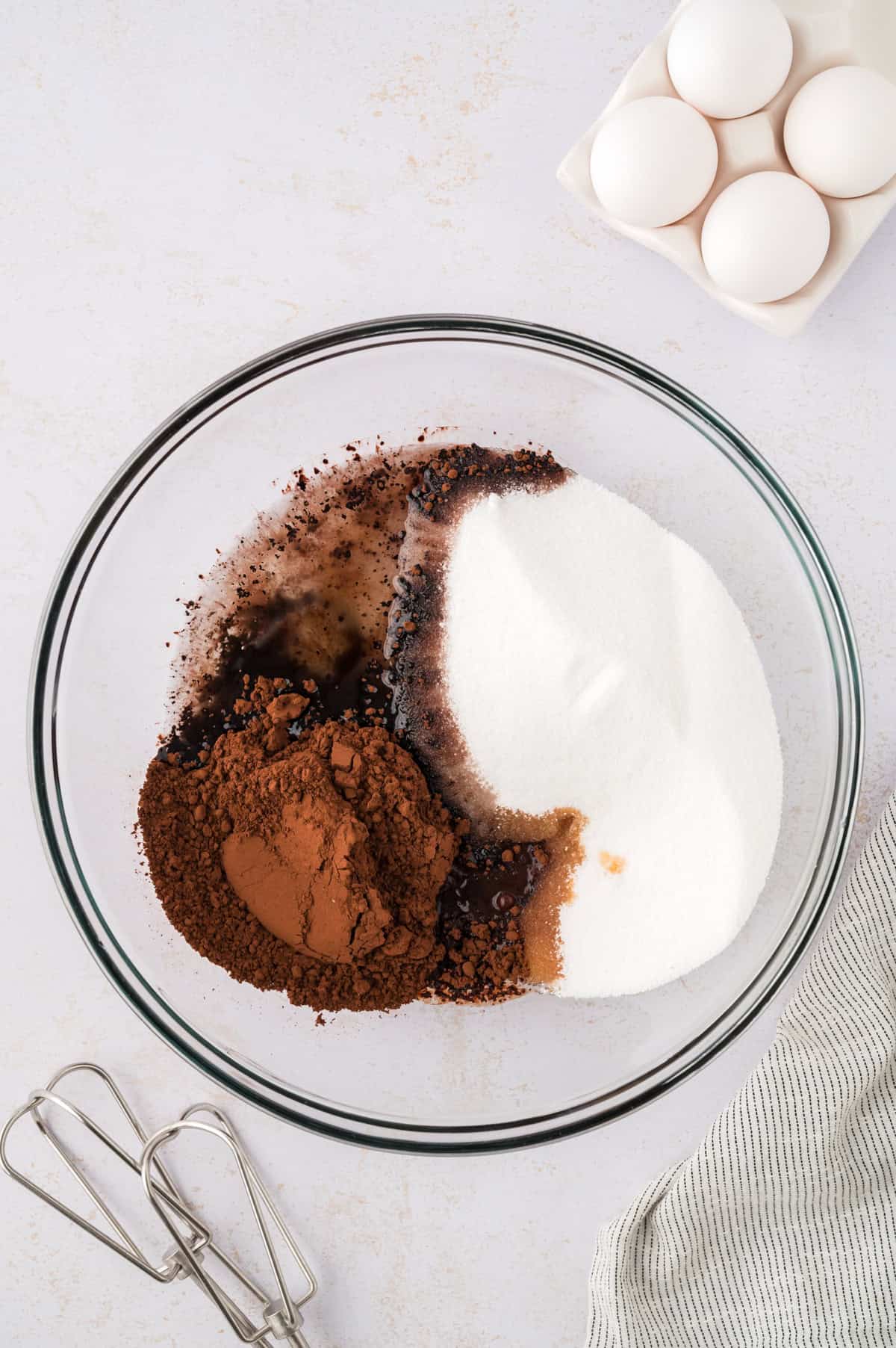 Ingredients for chocolate crinkle cookies in glass mixing bowl.