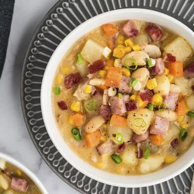 Ham and corn chowder in white bowl.