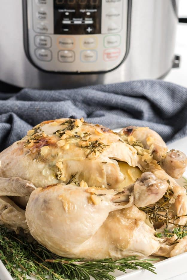 Instant Pot whole chicken on a bed of herbs.