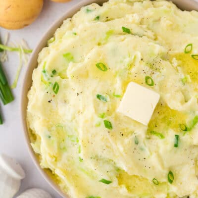 Overhead view of colcannon potatoes in bowl topped with pat of butter.