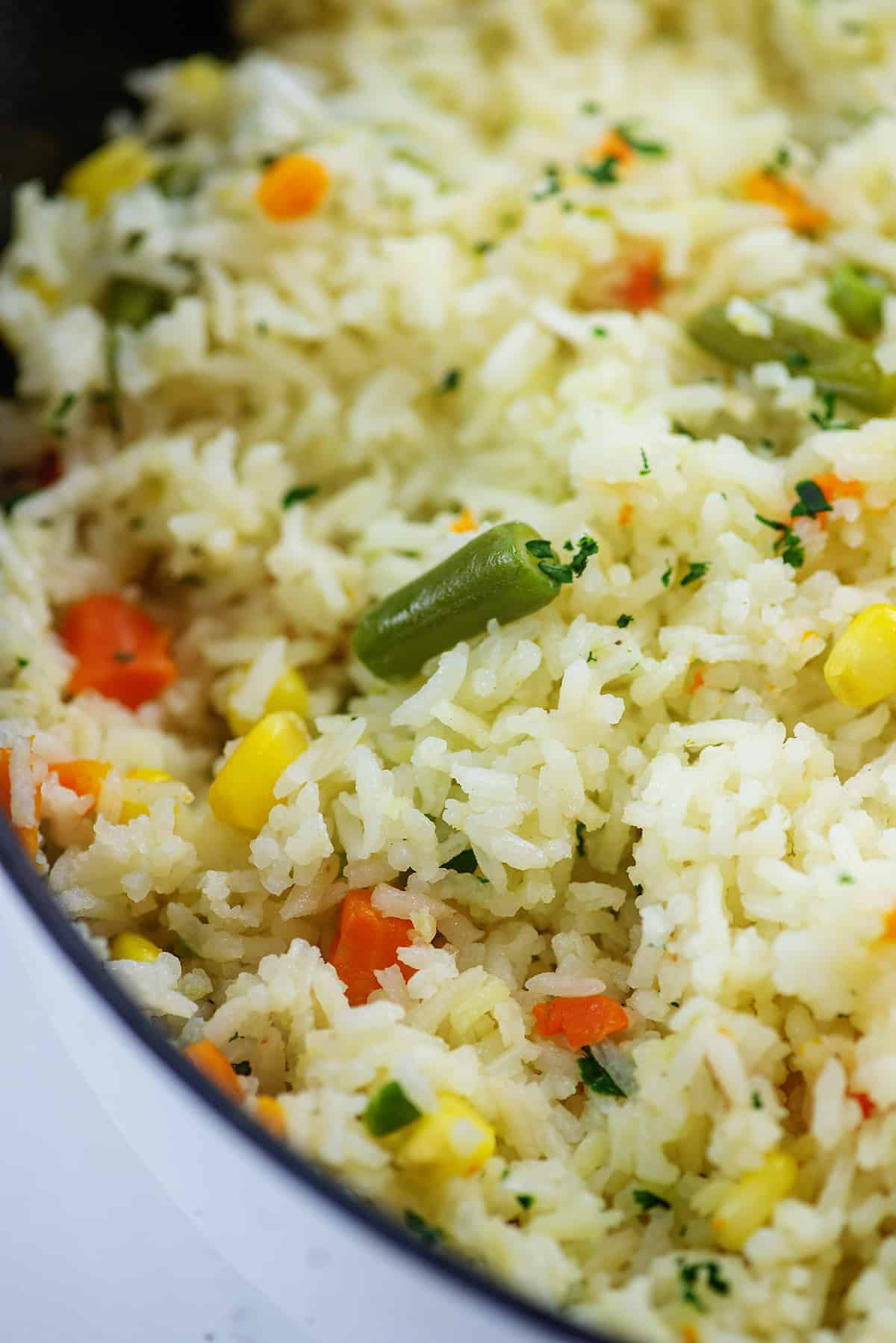 rice with mixed vegetables in white pot.