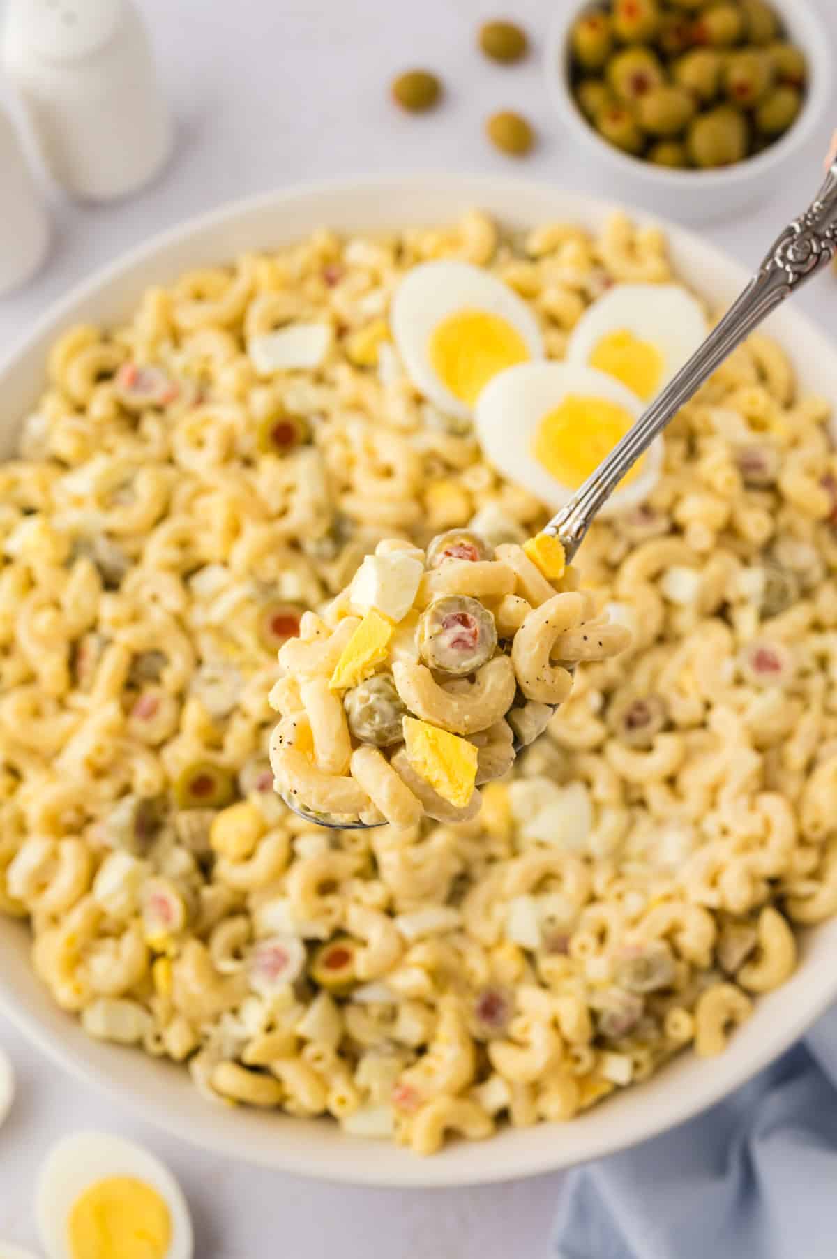 Mom's macaroni salad with olives on spoon.