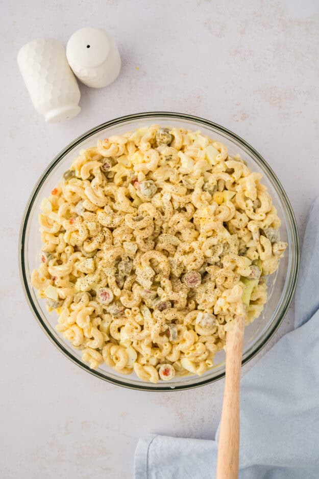 Chilled macaroni salad in glass bowl.