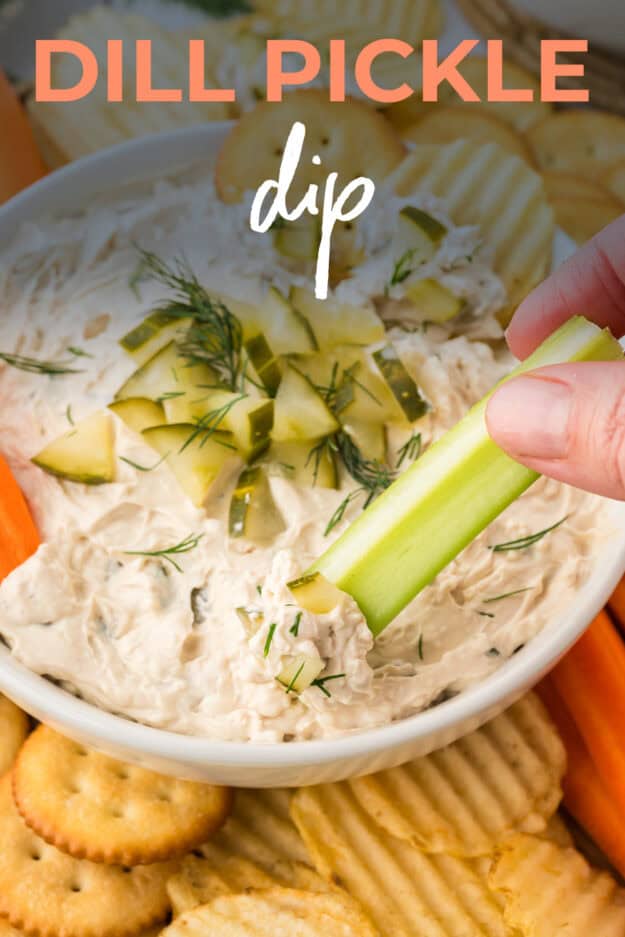 Hand dipping celery into pickle dip.