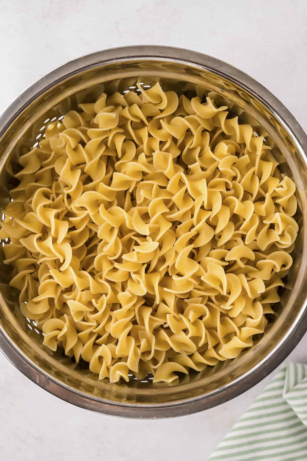 Boiled and drained egg noodles in colander.