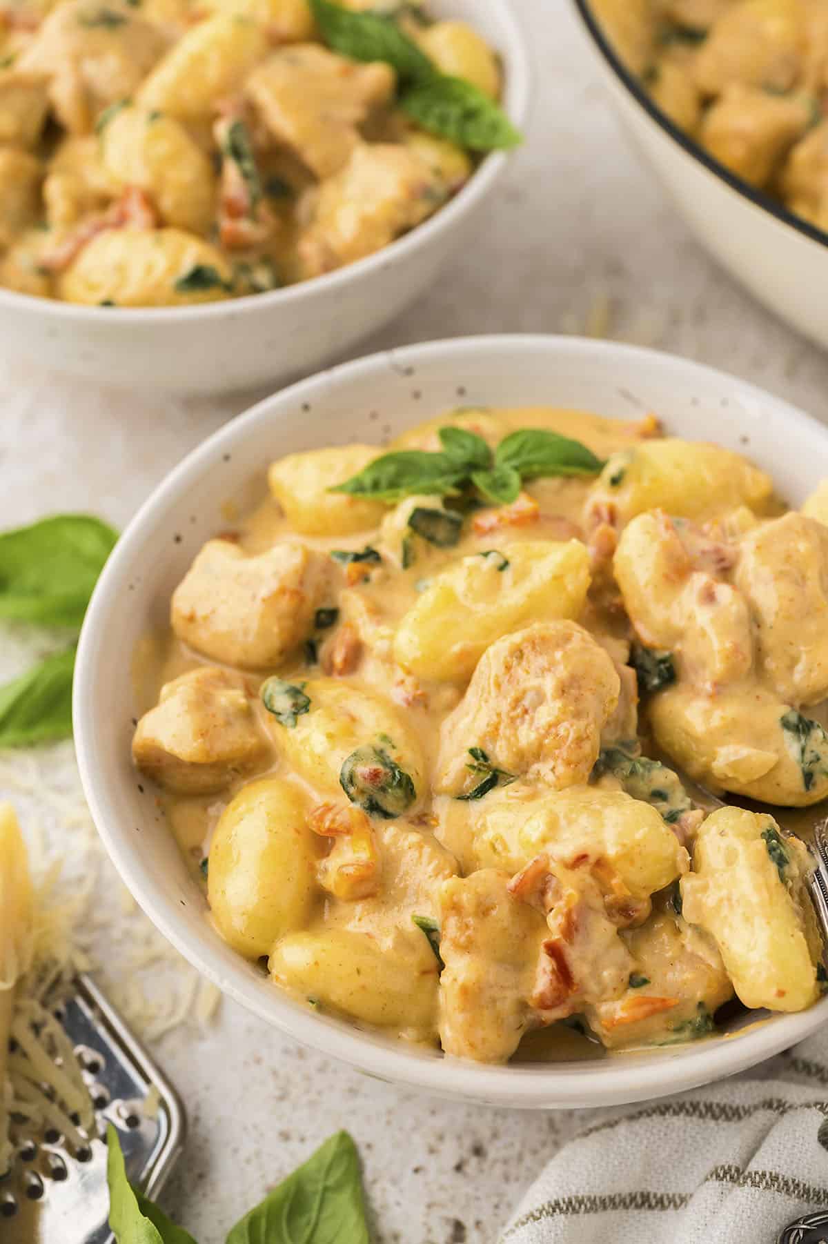 Creamy Tuscan chicken and gnocchi in bowl.