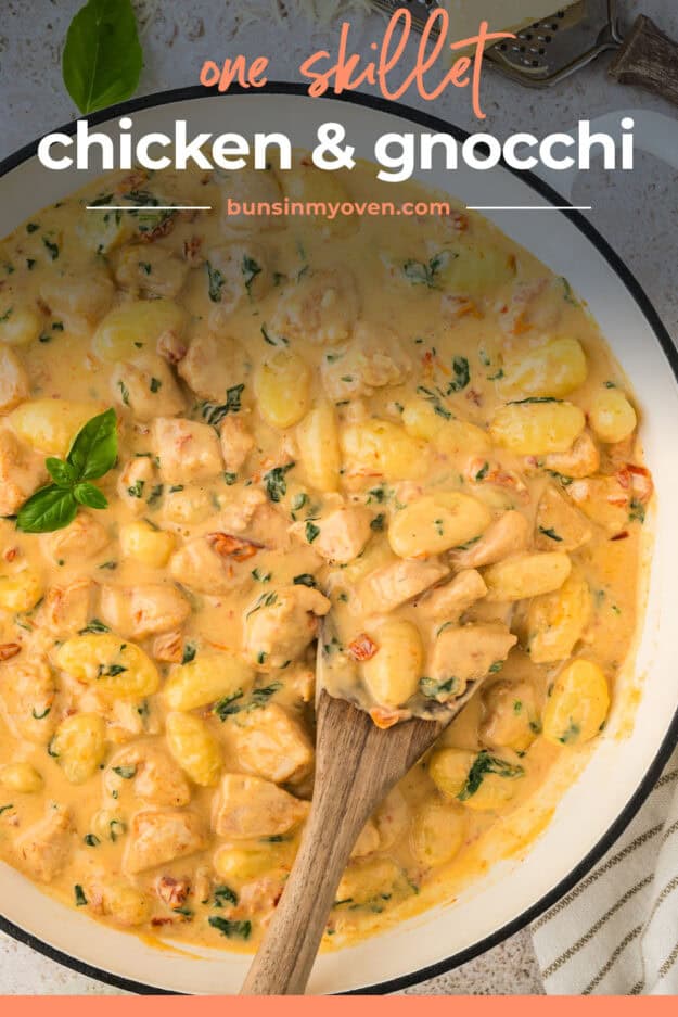 Skillet full of chicken and gnocchi in a Tuscan cream sauce.