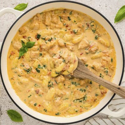 Chicken and gnocchi in a cream sauce in a skillet.