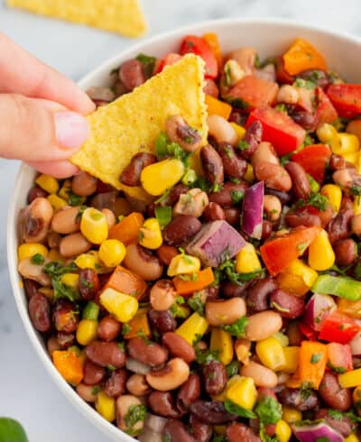 Hand dipping a chip into cowboy caviar.