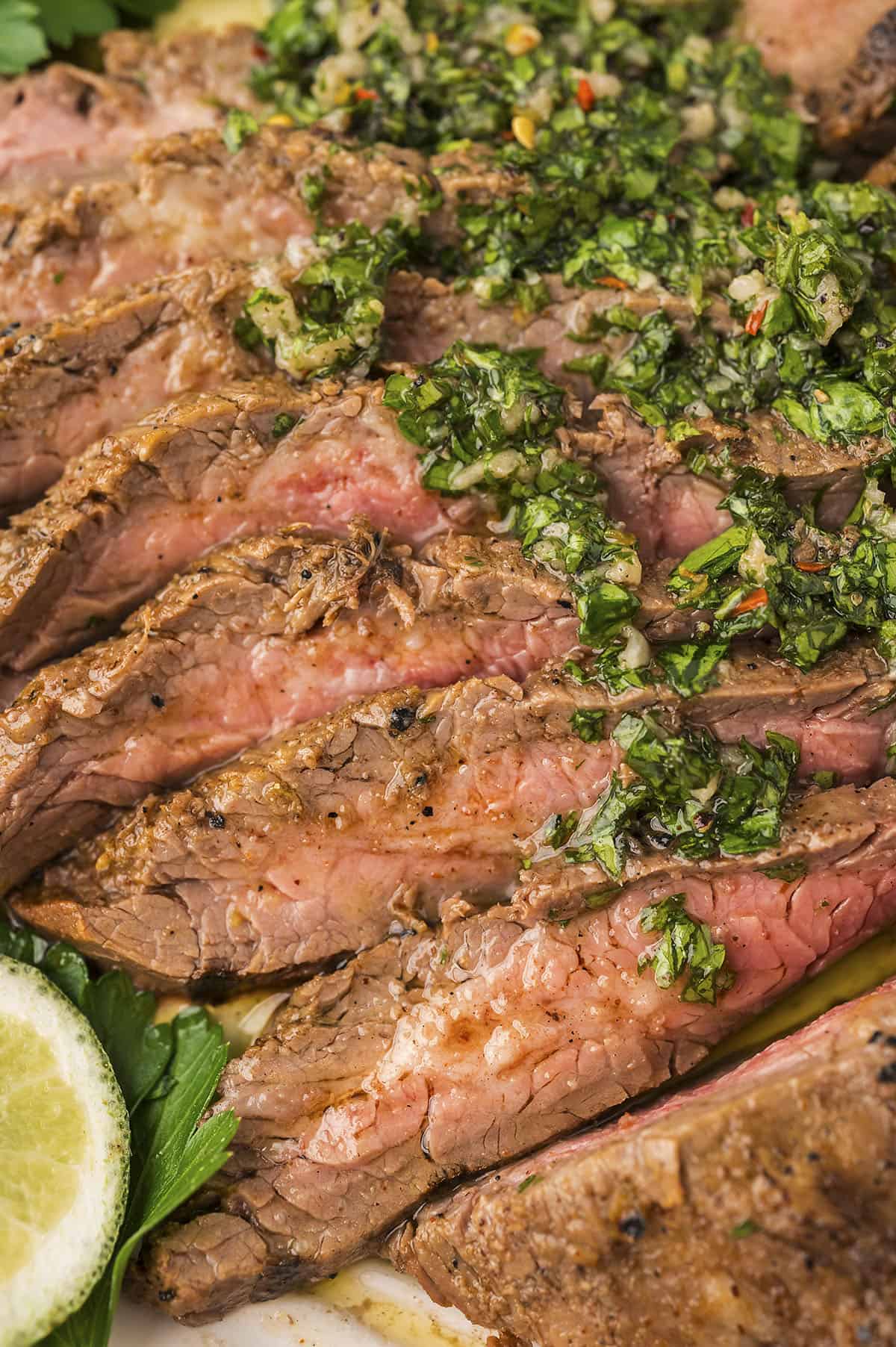 Sliced flank steak topped with chimichurri.
