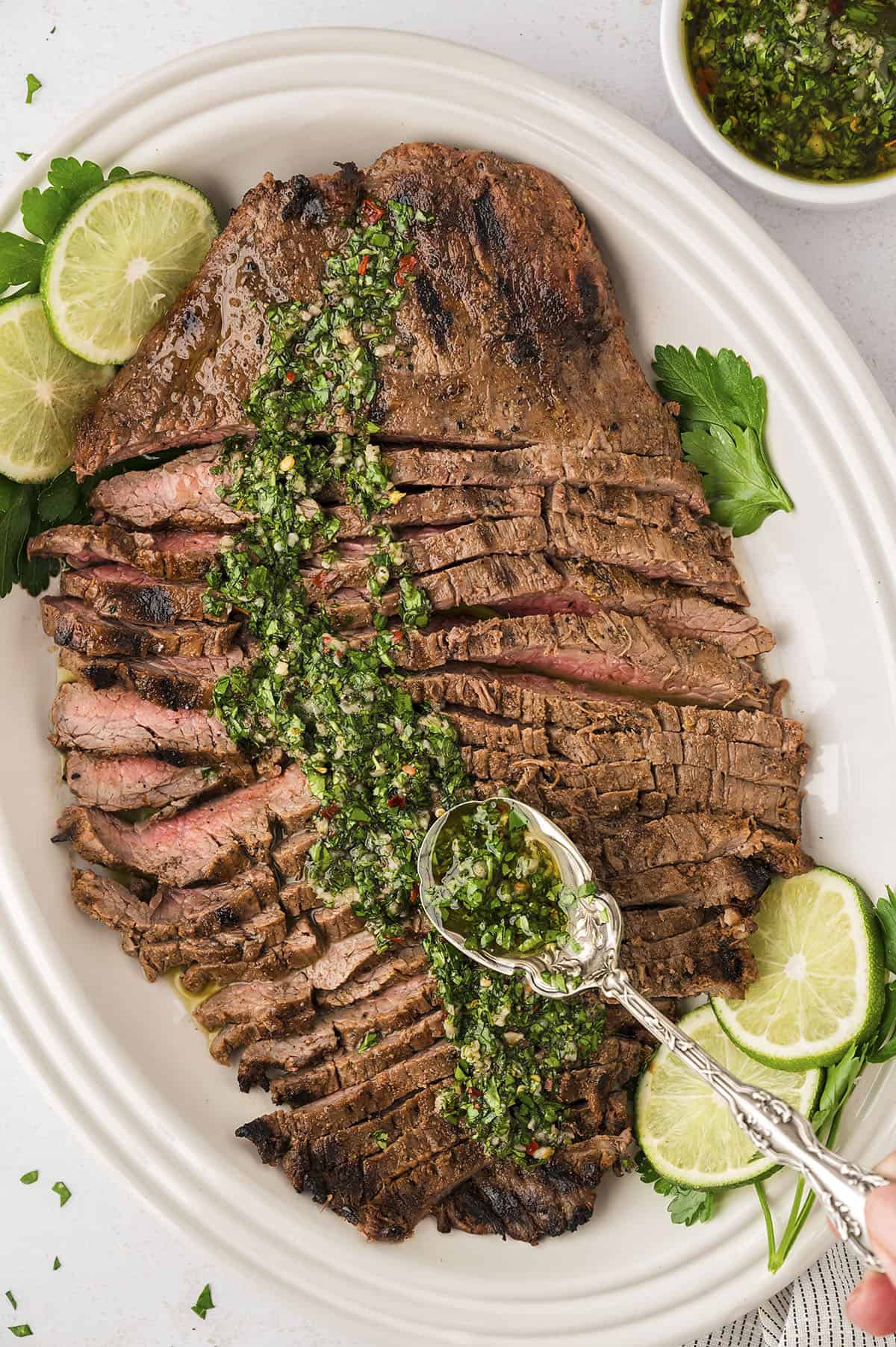 Flank steak with chimichurri on platter.