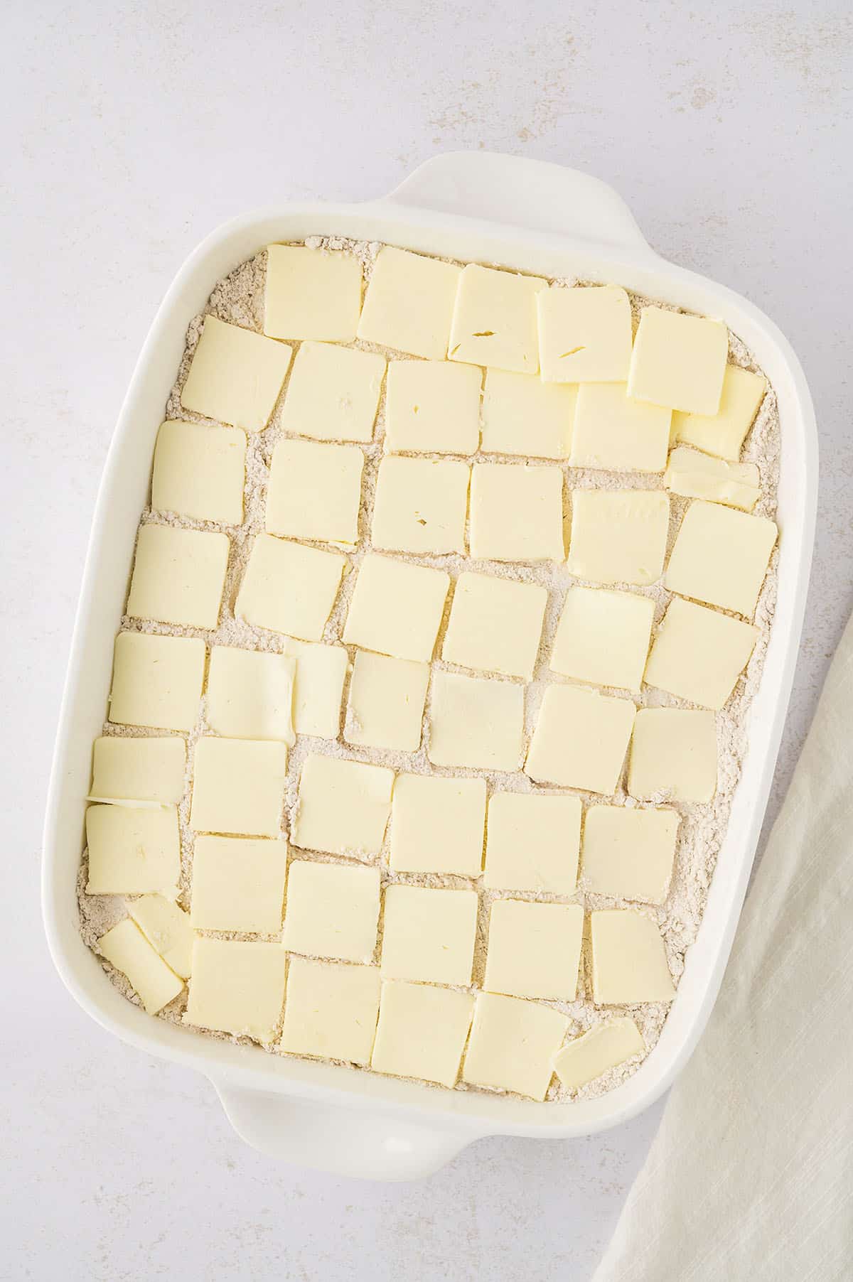 Pats of butter arranged over dry cake mix.