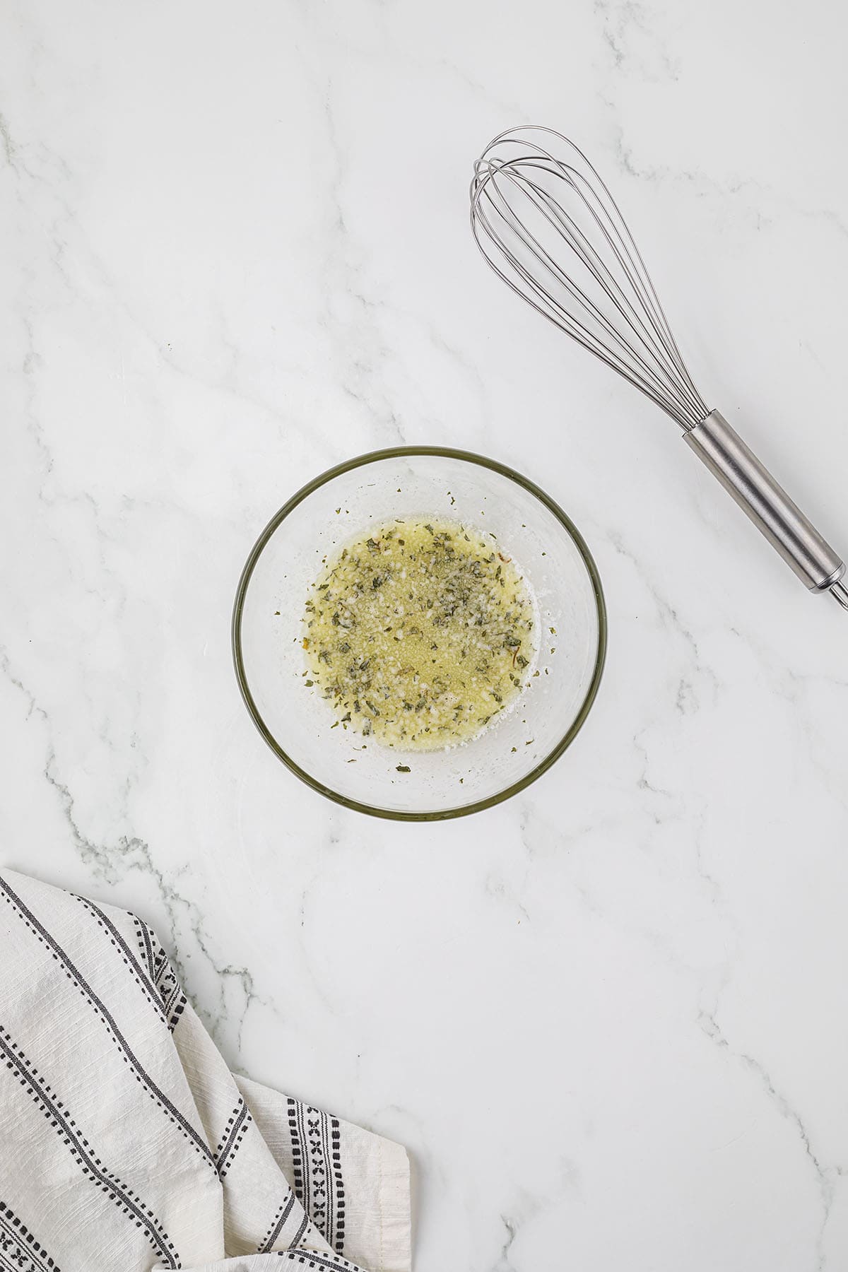 Garlic butter sauce in small glass bowl.