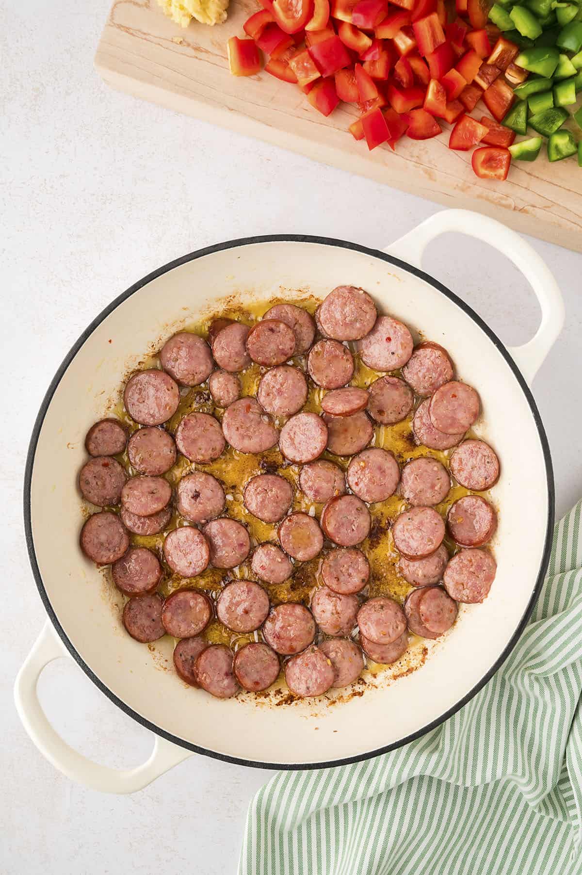 Andouille sausage being browned in a skillet.