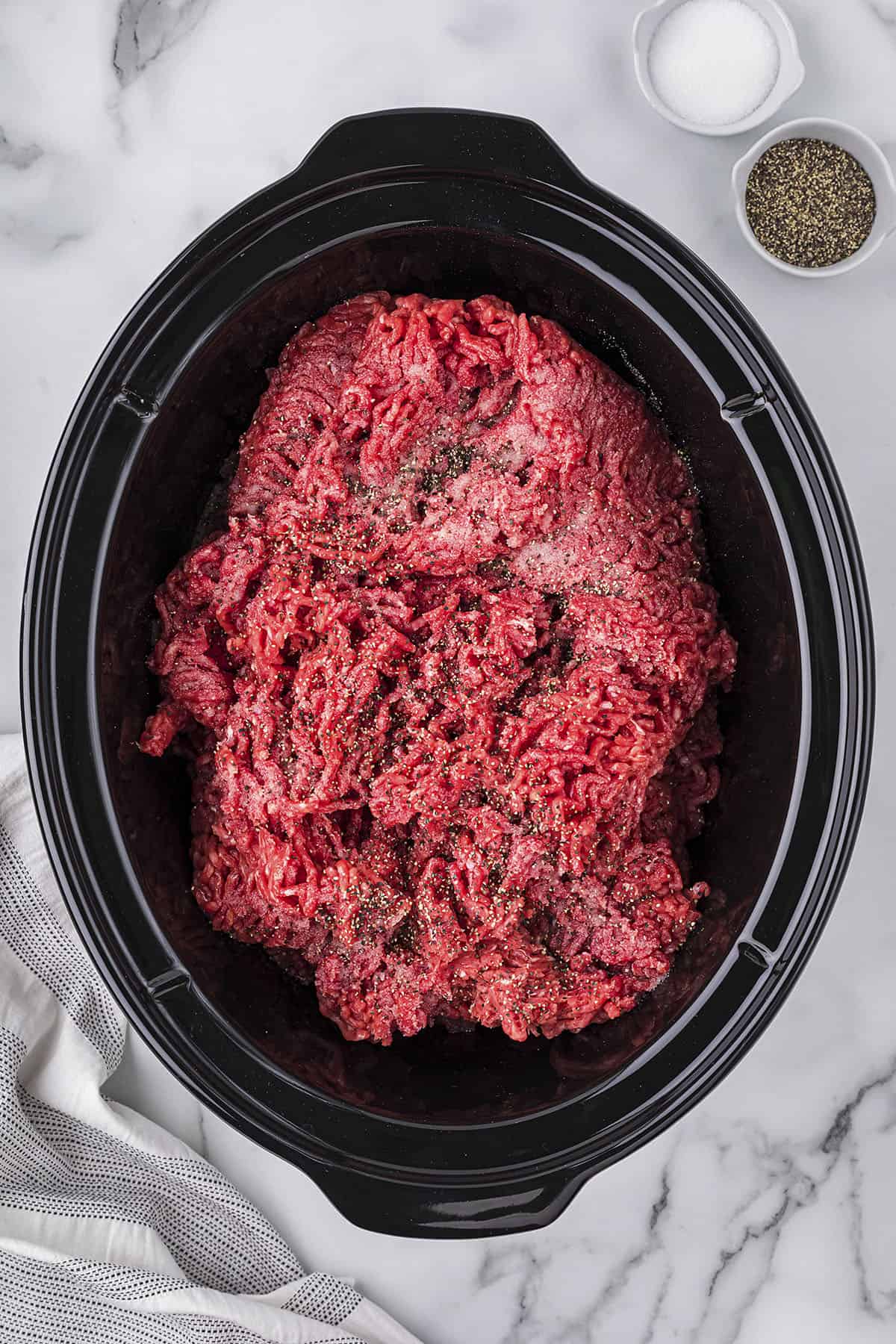 Raw ground beef in slow cooker.