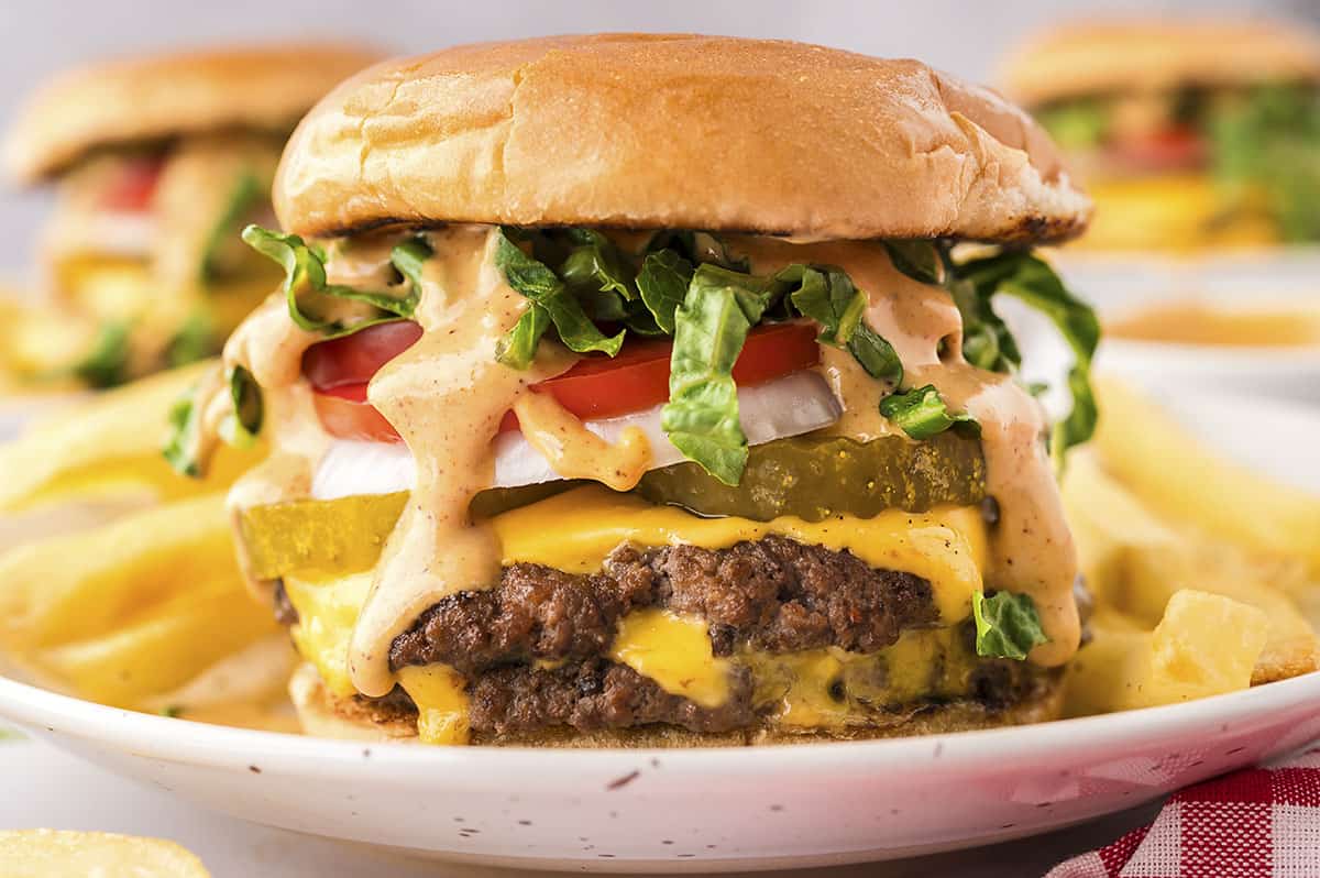 Smashburger on white plate with fries.