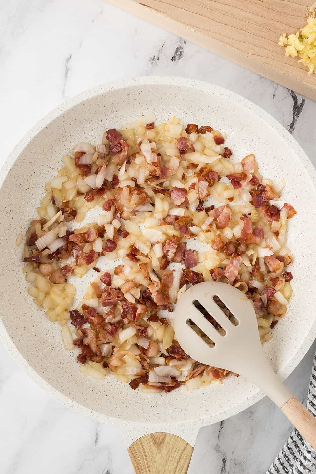 Cooked bacon, onion, and garlic in a skillet.