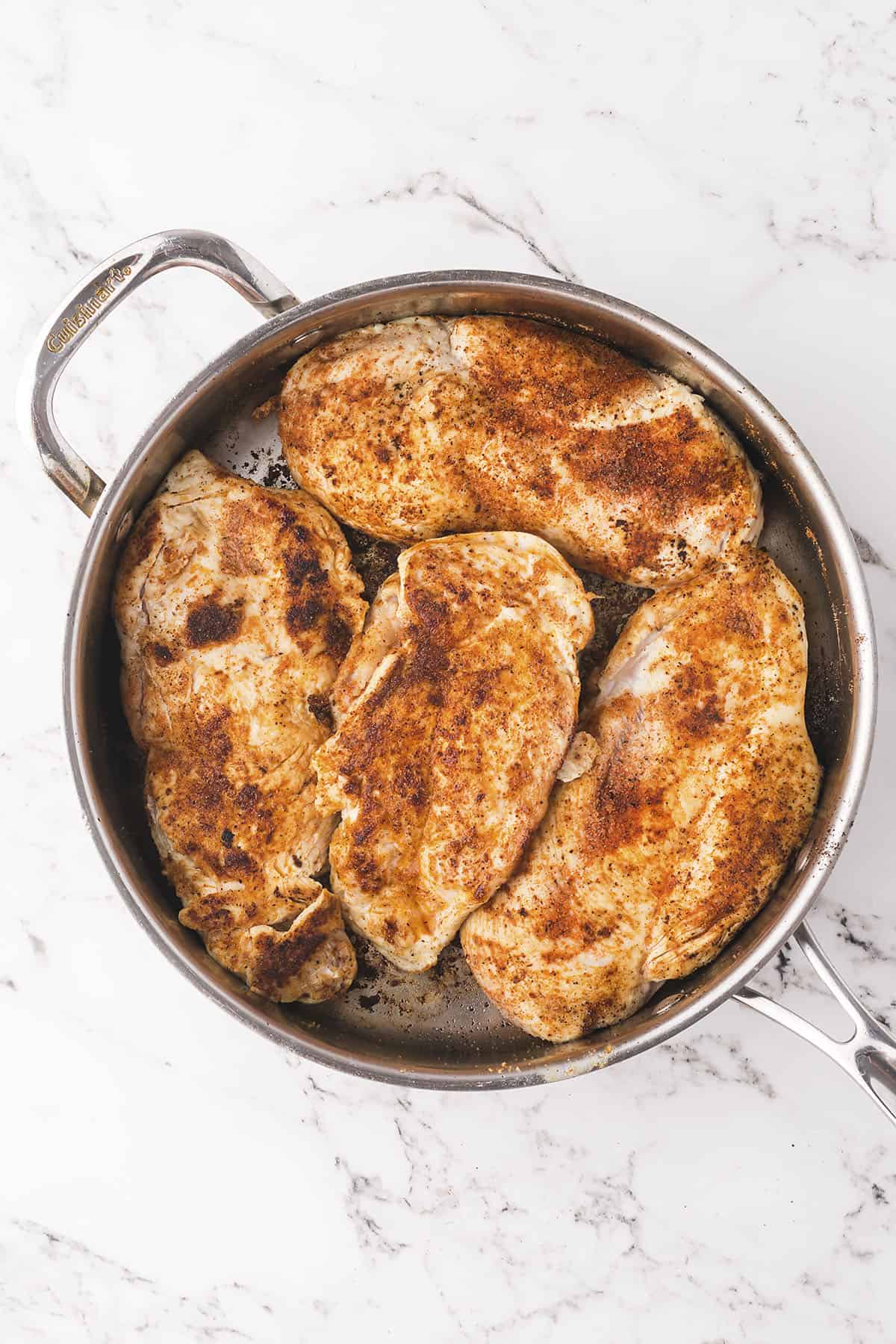 Chicken seared in skillet.