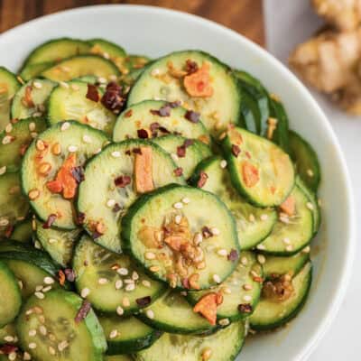 Asian cucumber salad in white bowl.