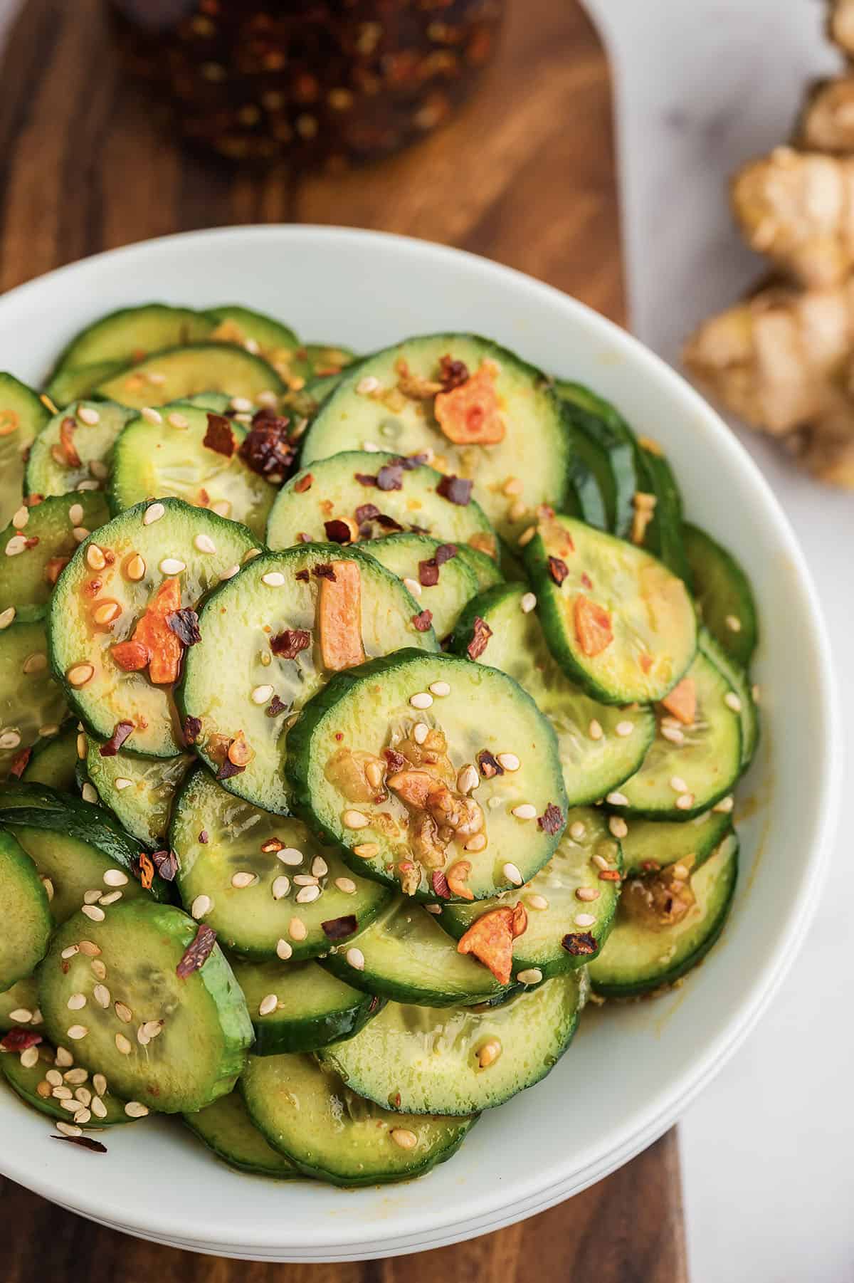 Asian cucumber salad in white bowl.