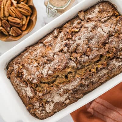 Apple bread in white ceramic loaf pan.