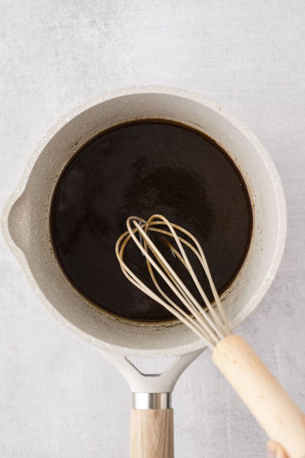 Egg roll sauce in pot with whisk.