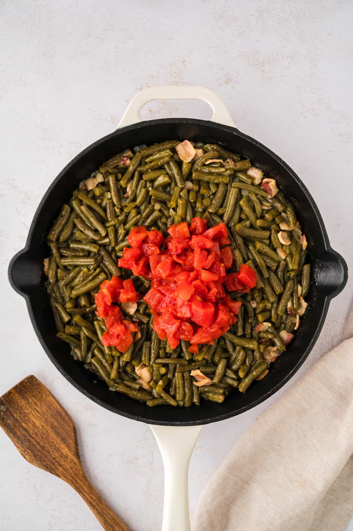 Tomatoes in skillet with green beans.