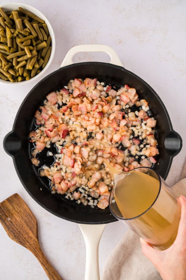 Bacon and onion in skillet with chicken broth.