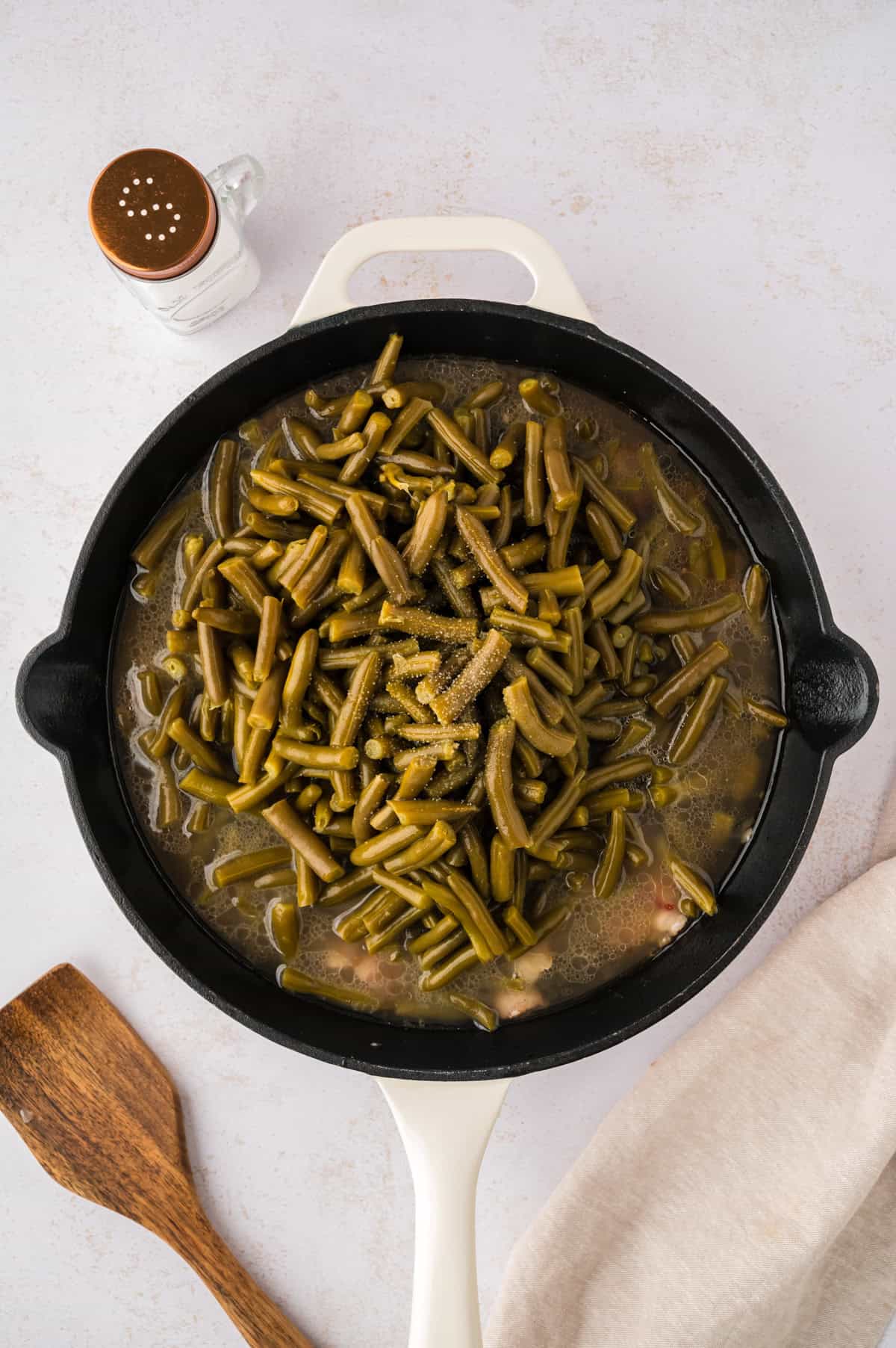 Green beans in skillet with chicken broth.