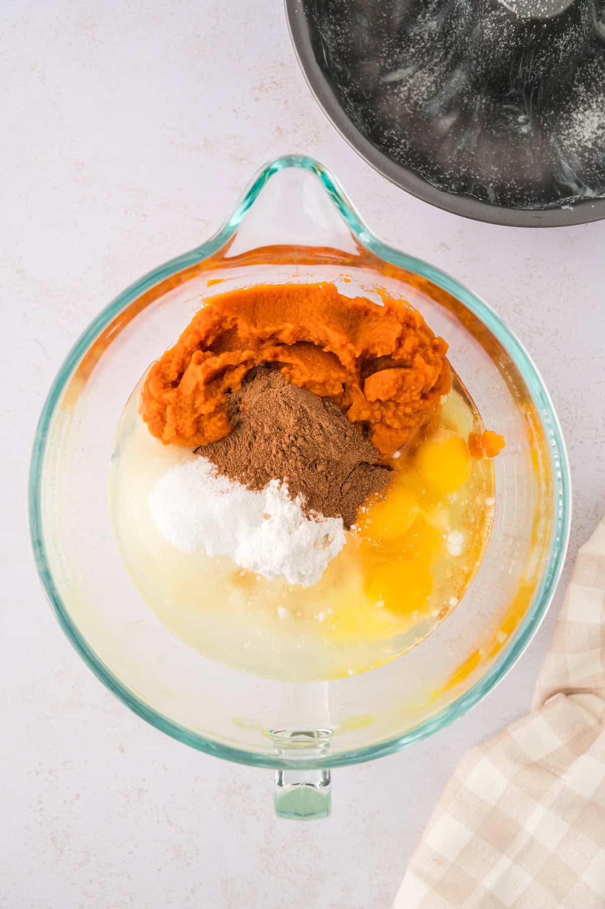 Ingredients for pumpkin bundt cake in mixing bowl.