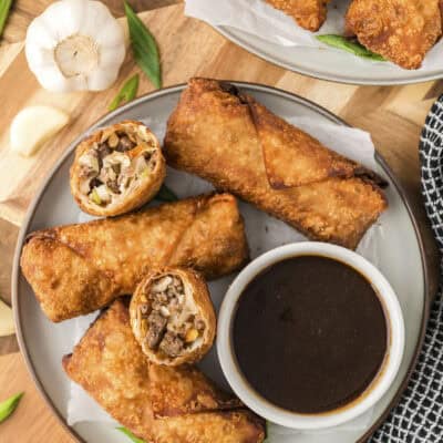 Pork egg rolls on plate with egg roll sauce.