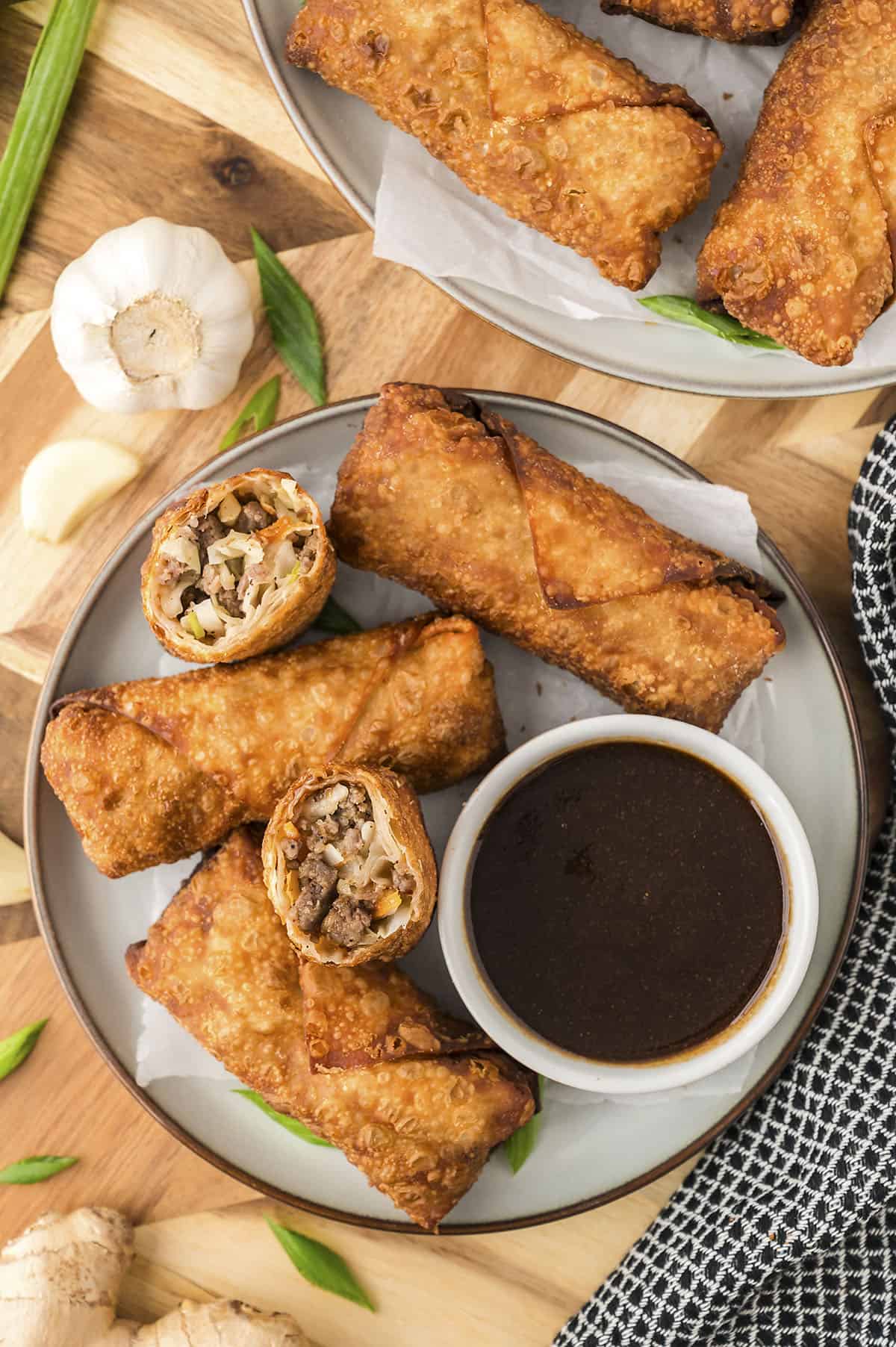 Pork egg rolls on plate with egg roll sauce.