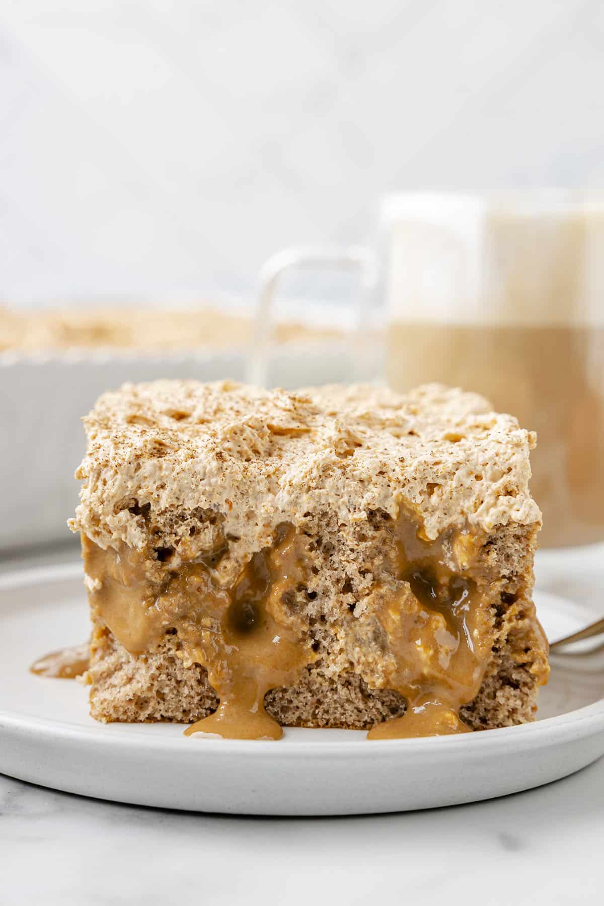 Pumpkin poke cake on white plate.