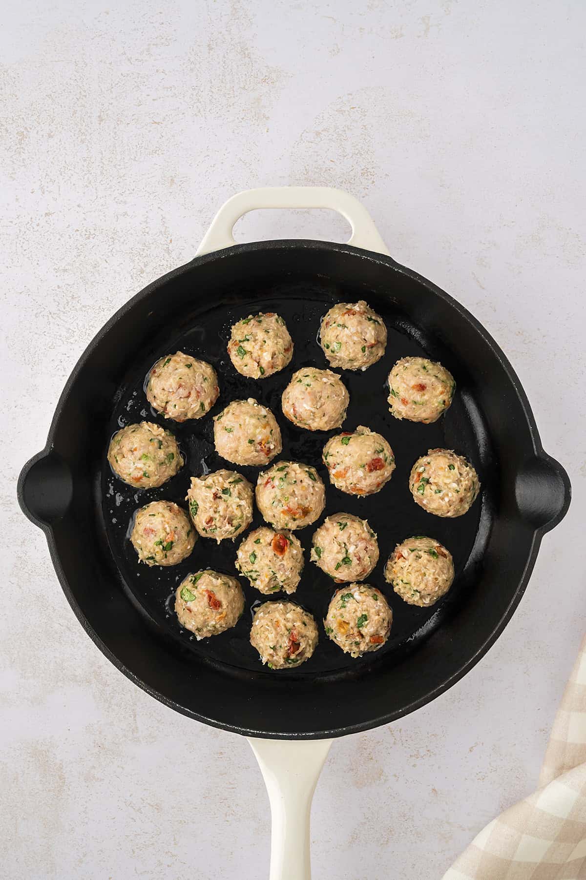 Tuscan chicken meatballs in skillet.