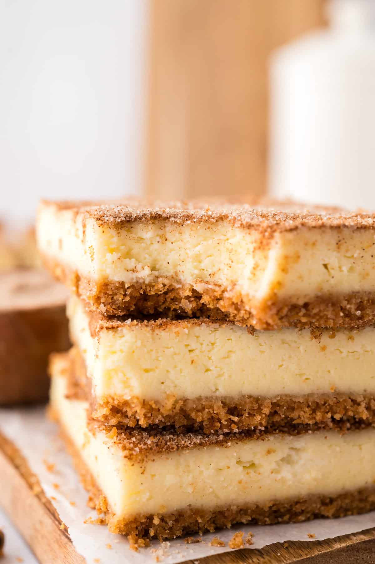 Snickerdoodle cheesecake bars stacked on counter.