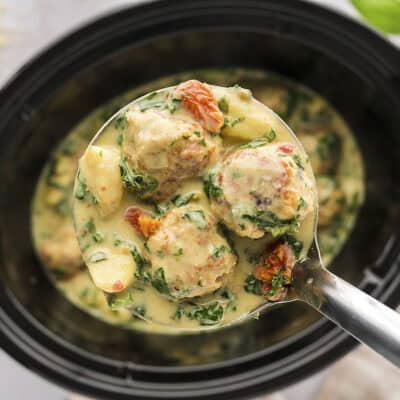 Slow cooker chicken meatballs with gnocchi on big spoon.