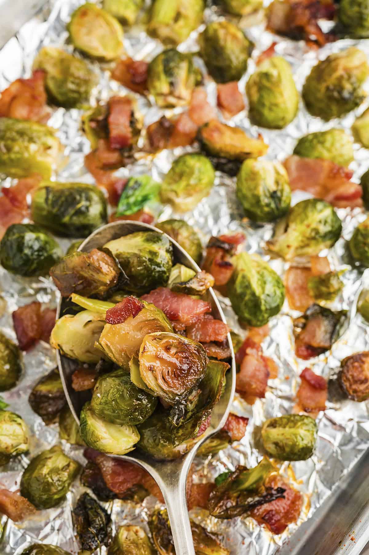 Roasted brussels sprouts on sheet pan lined with foil.