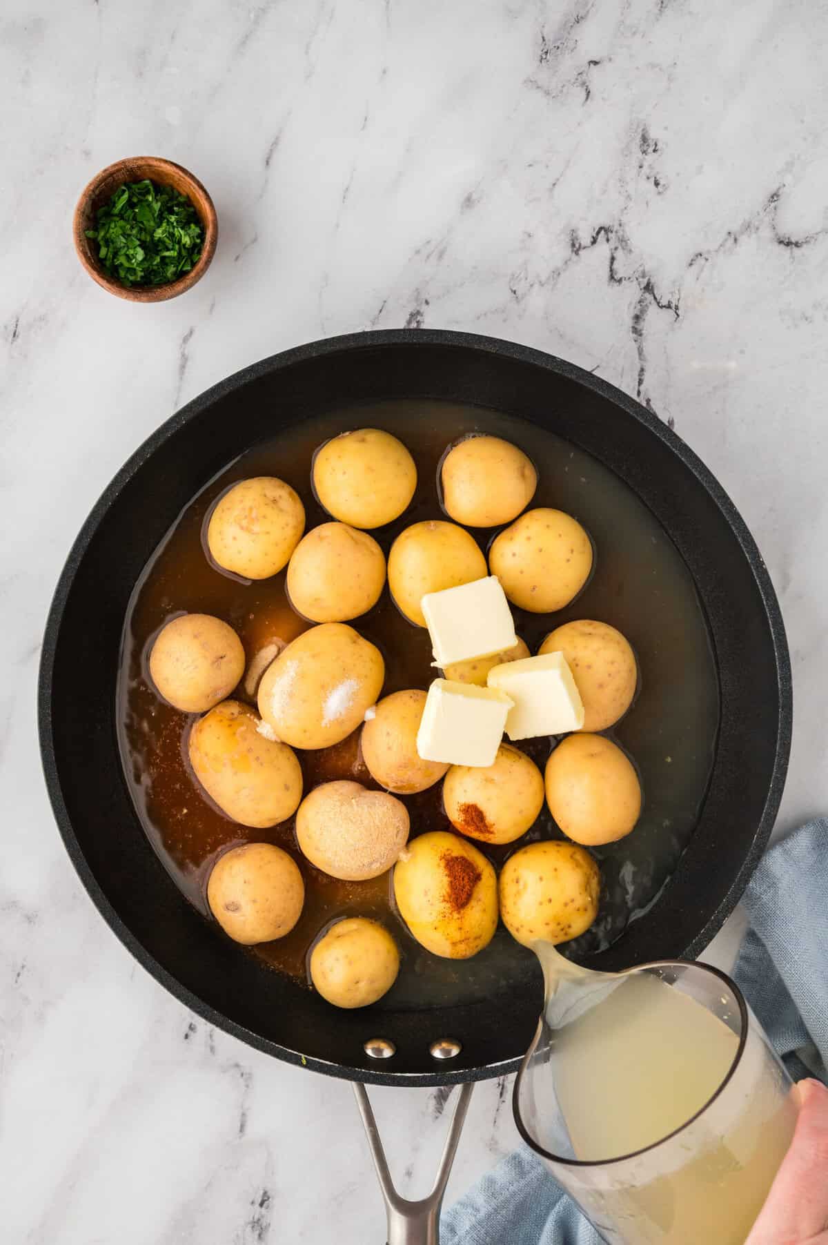 Potatoes and seasonings in skillet.