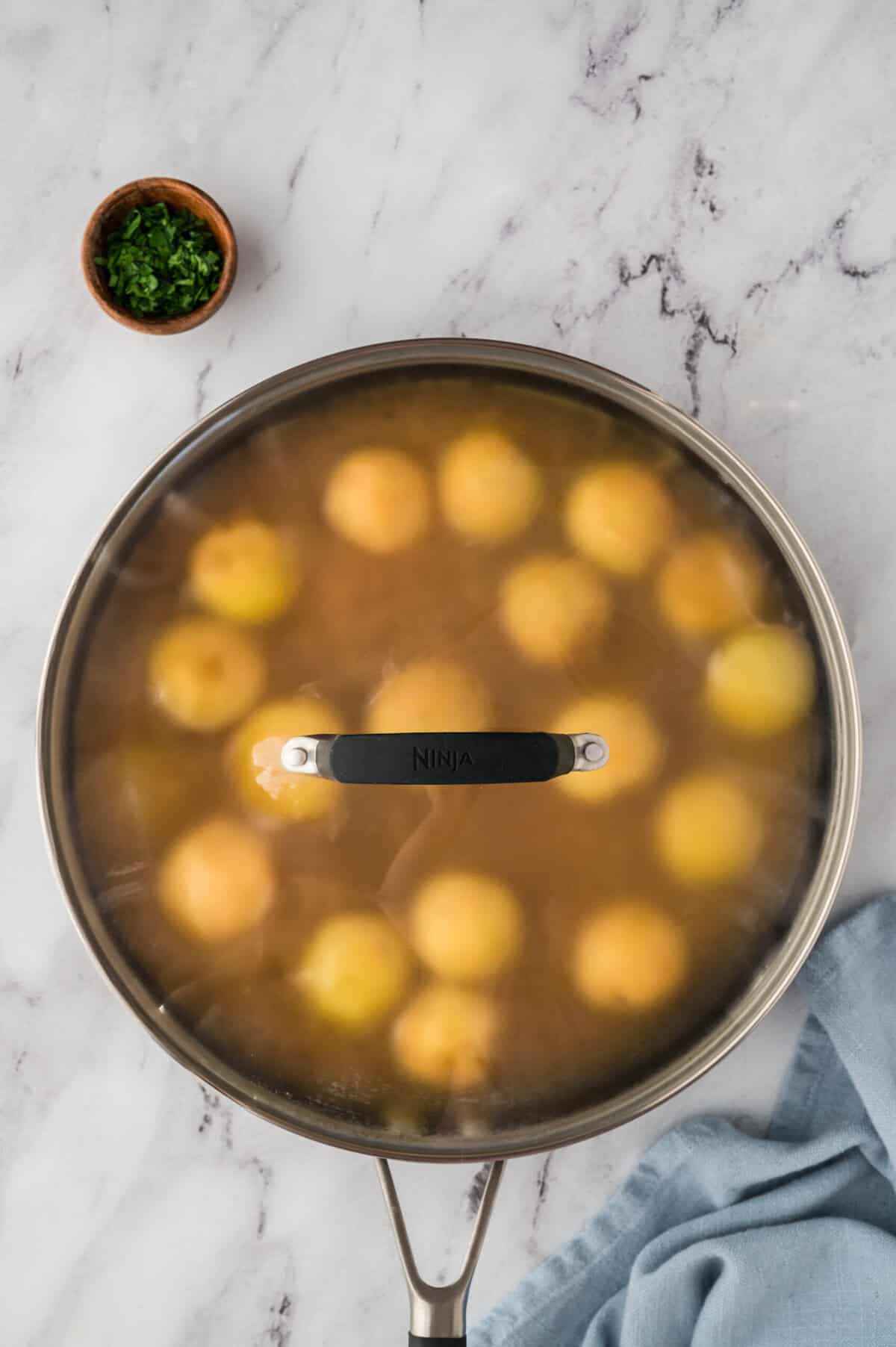 Boiling potatoes in skillet.